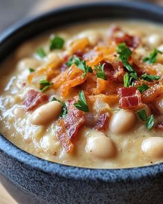 a bowl filled with beans and bacon on top of a table