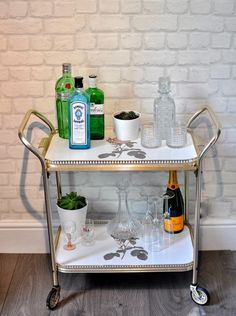 a bar cart with bottles and glasses on it