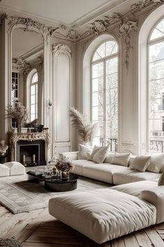 an elegant living room with white furniture and large windows