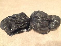 three bags of garbage sitting on the floor next to each other, one black and one gray