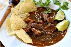 a white plate topped with meat and tortilla chips