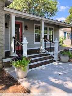 the front porch has two planters on it and is painted gray with white trim