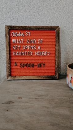 a sign that says what kind of key opens a haunted house? on a table next to a potted plant