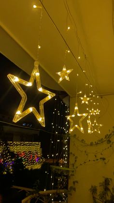 some lights that are hanging from the ceiling in front of a window with stars on it