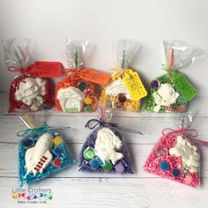 six small ornaments are in plastic bags on a white wooden surface with tags attached to them