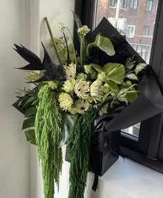 a bouquet of flowers sitting on top of a window sill