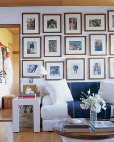 a living room filled with furniture and pictures on the wall above it's coffee table