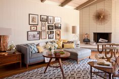 a living room filled with furniture and pictures on the wall above it's fireplace