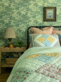 a bed in a bedroom with green wallpaper