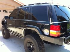 a black suv parked in front of a garage