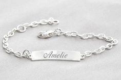 Designer bracelet with engraving made entirely of 925 sterling silver from the German jewelry brand BUBIDU. Exclusive silver bracelet for children as a special gift for baptism or communion with a 925 sterling silver plate with your desired name and date as well as your desired motif. You can have both the front and back engraved. You have a total of 15 characters including spaces at the front and 12 characters including spaces at the back. The bracelet has a lobster clasp and is adjustable in w Elegant Silver Bracelets With Names, Silver Name Charm Bracelet For Birthday, Silver Charm Bracelet With Name, Silver Name Charm Bracelet, Classic Silver Name Bracelet For Birthday, Silver Name Bracelet With Engraving Option, Silver Nameplate Bracelet With Custom Name, Silver Nameplate Bracelet With Names, Silver Nameplate Bracelets With Names