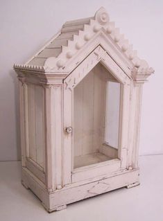 an old white cabinet with a mirror on the front and side doors open to reveal it's interior