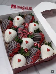 chocolate covered strawberries in a box with hearts on the top and red berries at the bottom