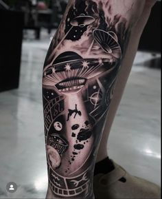 a man's leg with tattoos on it and an alien spaceship in the background