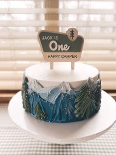 there is a cake that has been decorated with mountains and trees on it, which reads jack is one happy camper