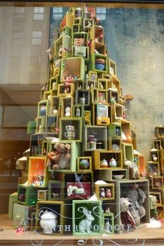 a christmas tree made out of bookshelves in front of a window with teddy bears