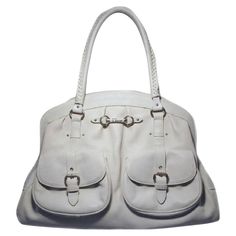 This stunning Christian Dior Shoulder bag is in good condition. The exterior features beautiful bone white leather trimmed with matte silver hardware. The double braided handles are not only extremely comfortable but also stylish. There are two front flap pockets with snap closures for ease of access to belongings you need immediate access to. Overall good condition. one 2'' scuff along bottom of front left exterior pocket (see photo) and some darkened piping on bottom corners. Not immediately v Dior Shoulder Bag, Limited Edition Bag, Double Braid, Monogram Tote Bags, Monogram Tote, Bone White, City Bag, Leather Fringe, Shopper Bag