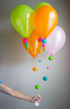 a person holding several balloons in their hand