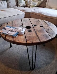 a wooden table with hairpin legs on the floor in front of a couch and coffee table