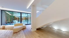 a modern living room with wood floors and white furniture, along with large glass windows