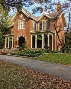 a large brick house sitting on top of a lush green field