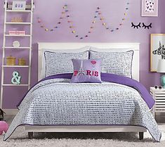 a bedroom with purple walls and bedding in the center, along with white shelving