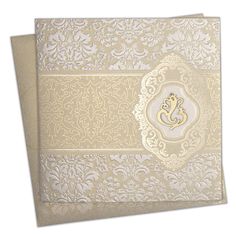 the wedding card is decorated with gold and white damasks, which are accented with