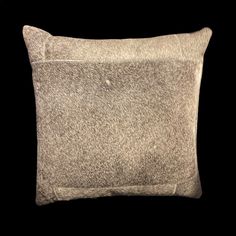 a gray pillow on a black background