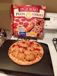 a pizza sitting on top of a stove next to a box of cookies