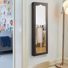 a mirror on the wall next to a floor lamp