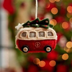 a red bus ornament hanging from a christmas tree