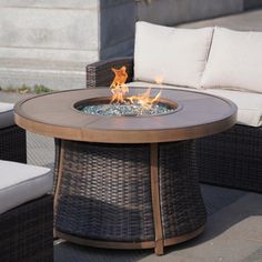 a fire pit sitting on top of a wooden table next to a couch and chair