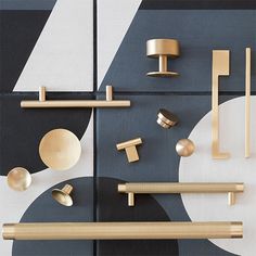 an assortment of brass handles and knobs on black, white, and grey tiles