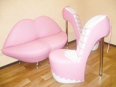 a pair of pink high heeled shoes sitting on top of a wooden floor next to a couch