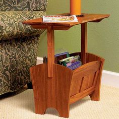 a small wooden table with a magazine rack on it and a candle in the middle