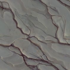 an aerial view of the surface of a rock formation, with small cracks in it