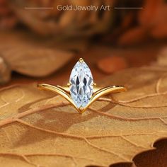 a gold jewelry art ring with a pear shaped blue topazte surrounded by leaves