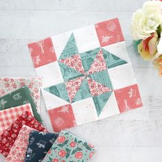 four different quilts laid out next to each other on a white table with flowers in the background