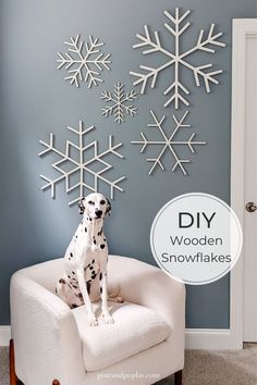 a dalmatian sitting in a chair with snowflakes on the wall behind it