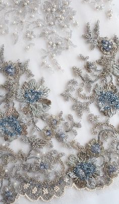 Couture French Lace | Silver Metallic Lace embroidered with a vintage feel and tiny accents of blue Elegant Silver Floral Embroidered Fabric, Blue Embellished Embroidered Fabric For Wedding, Elegant Silver Embellished Embroidered Fabric, Elegant Blue Embroidered Fabric For Evening, Elegant Blue Embroidered Fabric With Floral Details, Elegant Blue Floral Embroidered Fabric, Festive Silver Embellished Embroidered Fabric, Elegant Blue Embellished Embroidered Fabric, Elegant Embroidered Multicolor Fabric