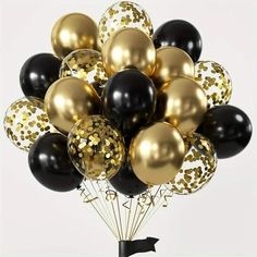 a bunch of black and gold balloons in the shape of a bouquet with confetti