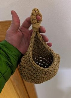 a hand holding a bag with a knot in it