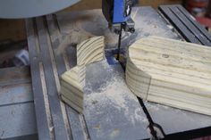 a piece of wood being worked on with a driller and milling machine in the background