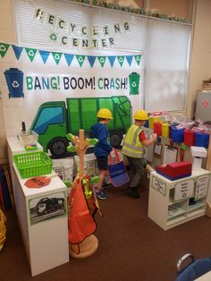 two children are playing in a playroom with toys and construction equipment on the floor