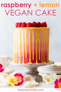 raspberry and lemon vegan cake on a plate with flowers in the background