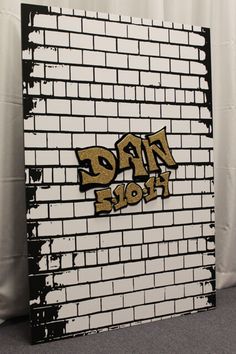 a brick wall with graffiti on it and the word rap written in gold spray paint