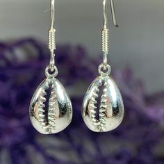 TAKE AN ADDITIONAL 20% OFF THE ALREADY REDUCED SALE PRICE - ADDITIONAL 20% IS DEDUCTED AT CHECKOUT Solid sterling silver The Goddess rises from the sea foam when a shell is tossed into the surf - this seashell symbolizes the beauty of woman and of the sea. This tiny Cowry (also spelled Cowrie) shell symbolizes the giver of life - woman and the gifts of fertility and abundance. A beautiful piece for any one who loves nature and power of a woman. 1/2" x 1/4" earrings in solid sterling silver with Silver Shell Gift, Silver Teardrop Earrings For Beach, Silver Teardrop Jewelry For Summer, Handmade Silver Shell For Beach, Silver Shell-shaped Jewelry Gift, Adjustable Silver Shell-shaped Jewelry, Silver Shell For Beach With Ocean-inspired Style, Handmade Silver Shell As A Gift, Silver Shell Earrings For Beach