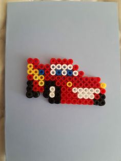 a red car made out of legos sitting on top of a white tablecloth