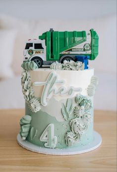 a birthday cake with a garbage truck on it's top and the number four