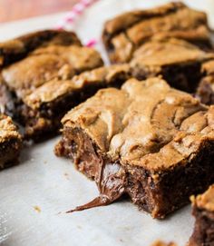 chocolate brownies cut into squares on a piece of parchment paper with one bite taken out